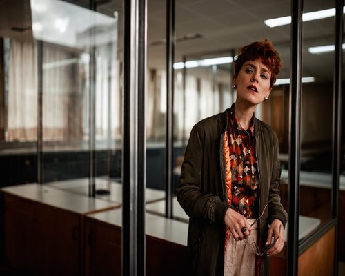 person standing and stretching by the office window